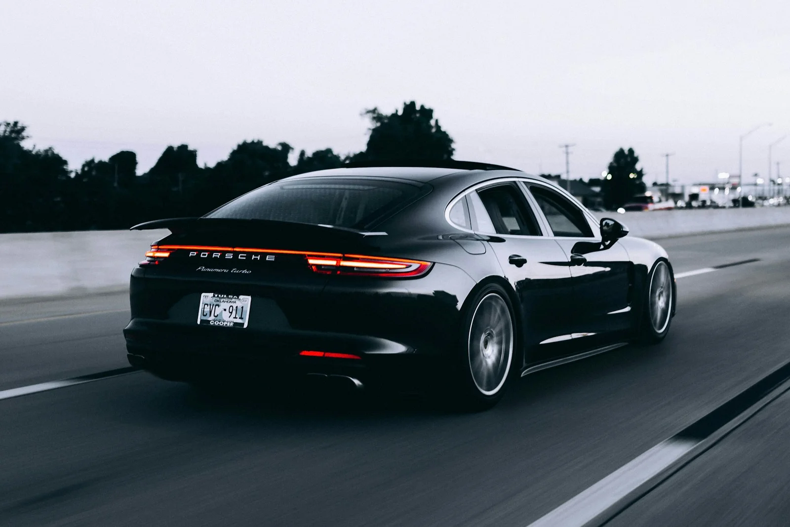 A dark Porsche travelling along a road